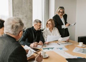 people with grey hair working around a conference table